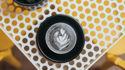 Bird's eye view of a mug with activated charcoal latte art of a leaf.